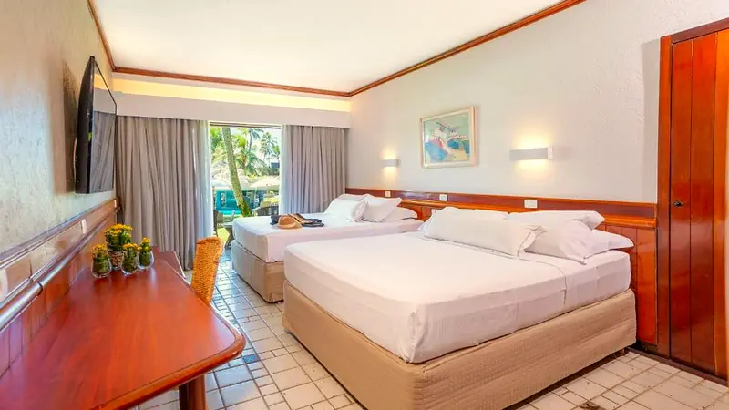 Apartamento Classic com duas camas de casal, mesa de madeira e janela para o jardim
