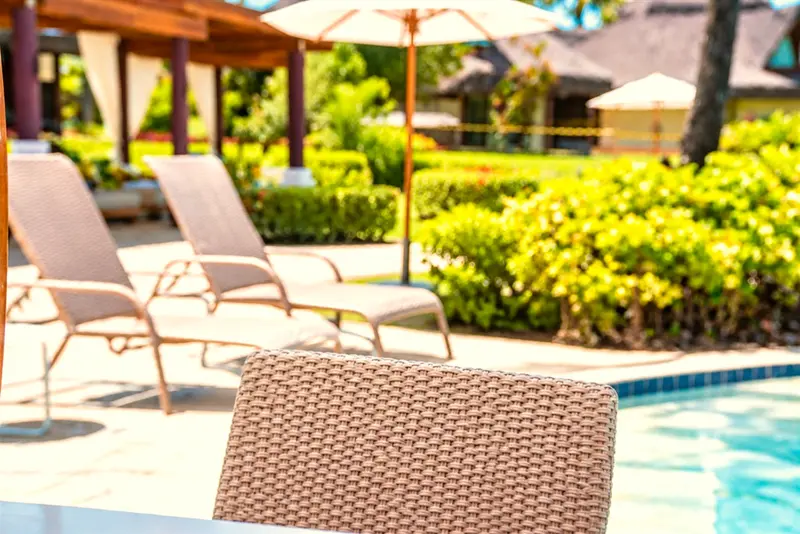 Espreguiçadeiras de fibra no jardim, à beira da piscina