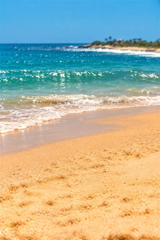 Ondas suaves chegando à areia dourada da praia
