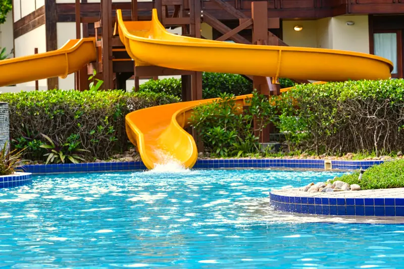 Toboágua amarelo de duas pistas descendo para a piscina