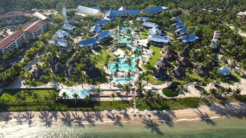 Vista aérea do resort com os bangalôs perto da areia e o mar à frente